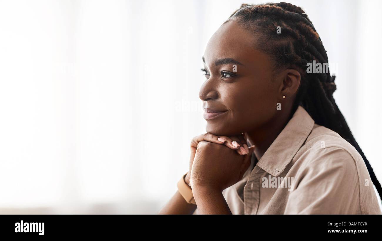 Planifier l'avenir. Vue latérale Portrait de la jeune femme afro-américaine pensive rêvant de jour Banque D'Images