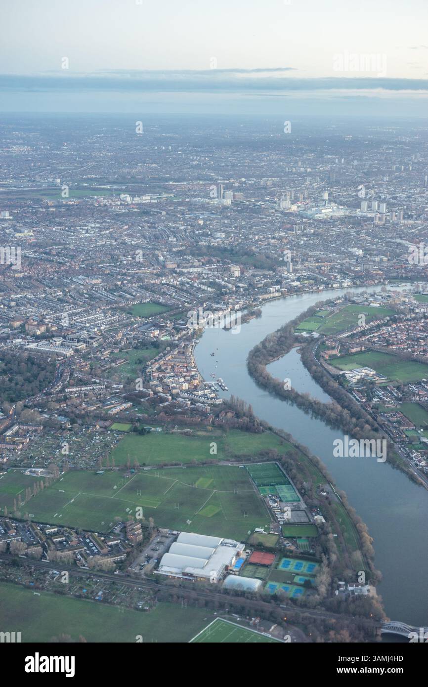 Vue aérienne de la banlieue de Londres à travers les nuages tôt le matin avec la Tamise coulant à l'heure dorée du lever du soleil près de la zone industrielle, United Kin Banque D'Images
