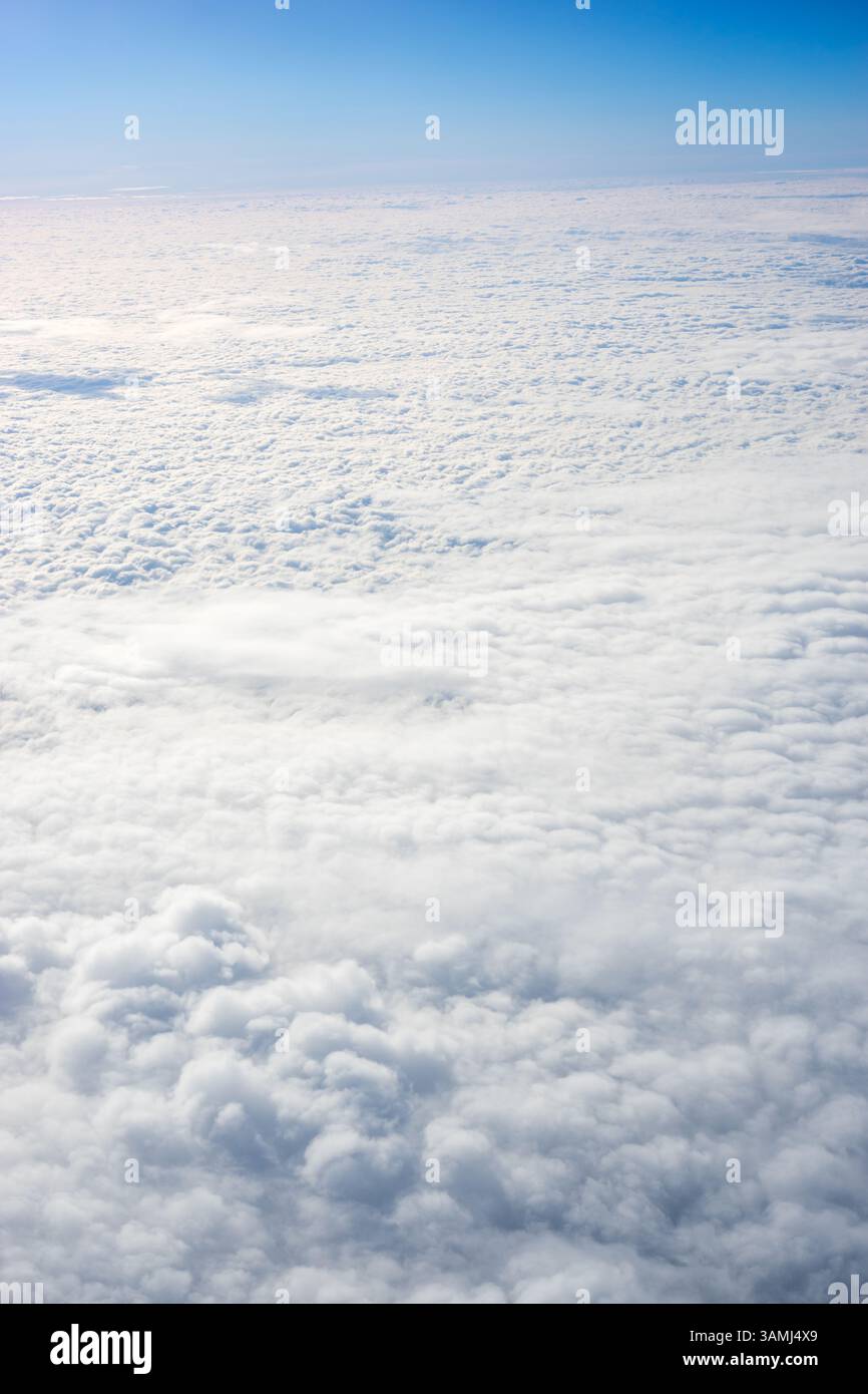 Vue de nuages depuis la fenêtre de l'avion, nuages dans un ciel bleu par une journée brillante Banque D'Images