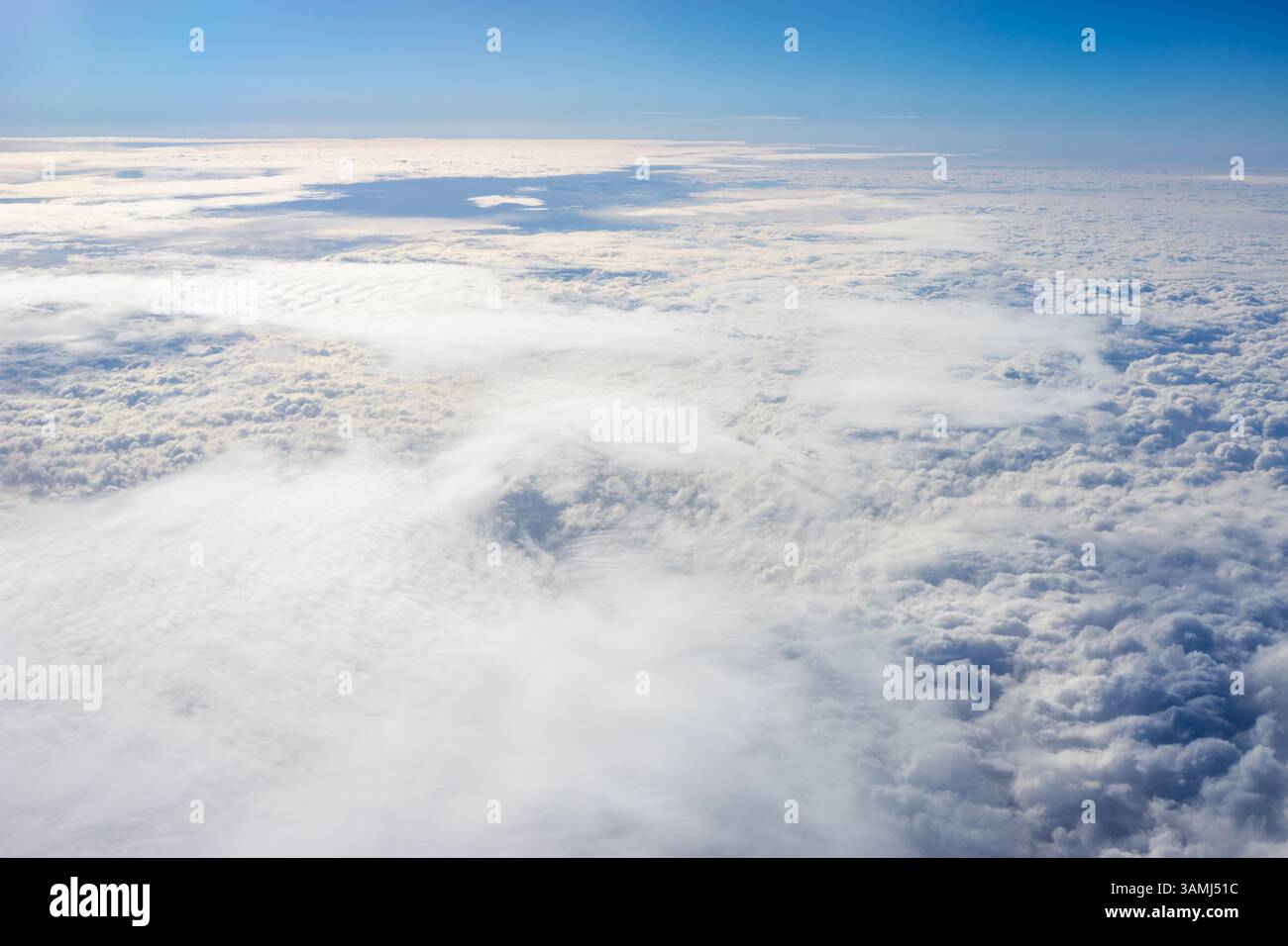 Vue de nuages depuis la fenêtre de l'avion, nuages dans un ciel bleu par une journée brillante Banque D'Images