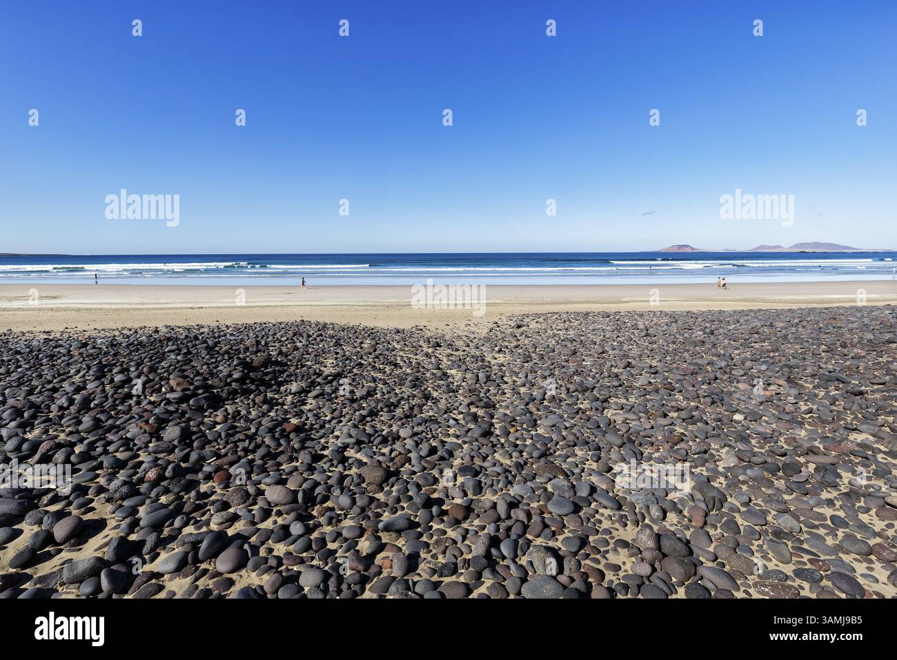 Galets noirs, roche volcanique, Playa de Famara, île de la Graciosa à l'horizon, la Caleta de Famara, Lanzarote, Espagne, Europe Banque D'Images