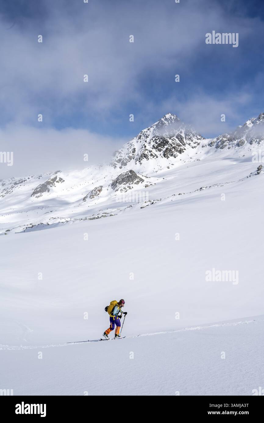 Randonneur de ski montant à travers un paysage de montagne pittoresque enneigé avec vue sur les sommets des montagnes, ascension au sommet de Kesch Pitschen, Buend Banque D'Images