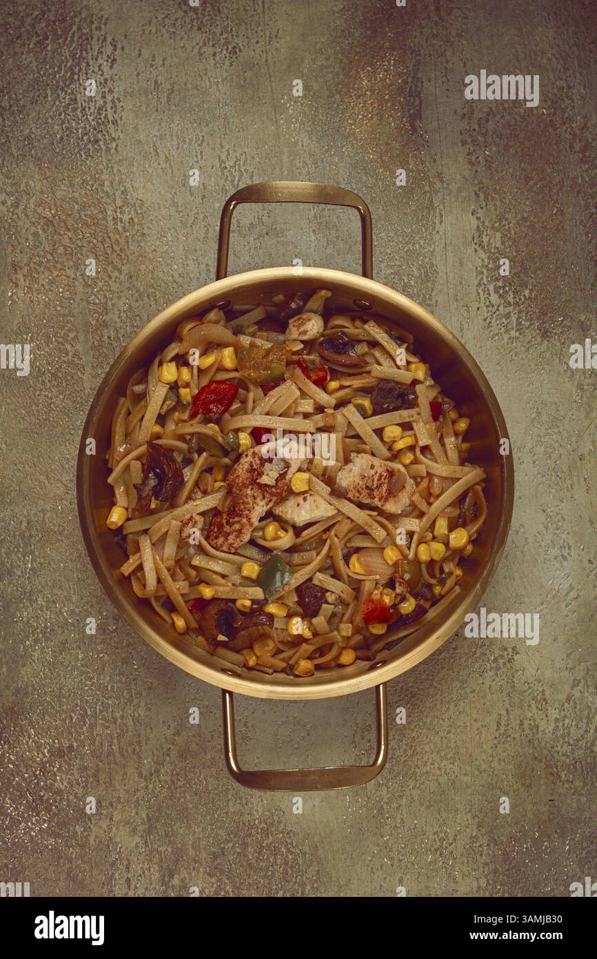 Nouilles frites avec viande de poulet et légumes, Bami Goreng, un plat indonésien, dans un pot en laiton, sans personnes Banque D'Images