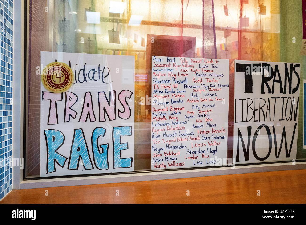 Pancartes autour de la libération et de la rage trans avec une liste de victimes de crimes haineux affichée au Centre de ressources LGBTQIA sur l'UC. Campus Davis. Banque D'Images
