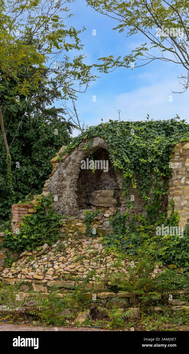 Un petit bâtiment avec du lierre poussant dessus. Le bâtiment est vieux et a un toit en pierre. Le ciel est bleu et il n'y a pas de nuages Banque D'Images
