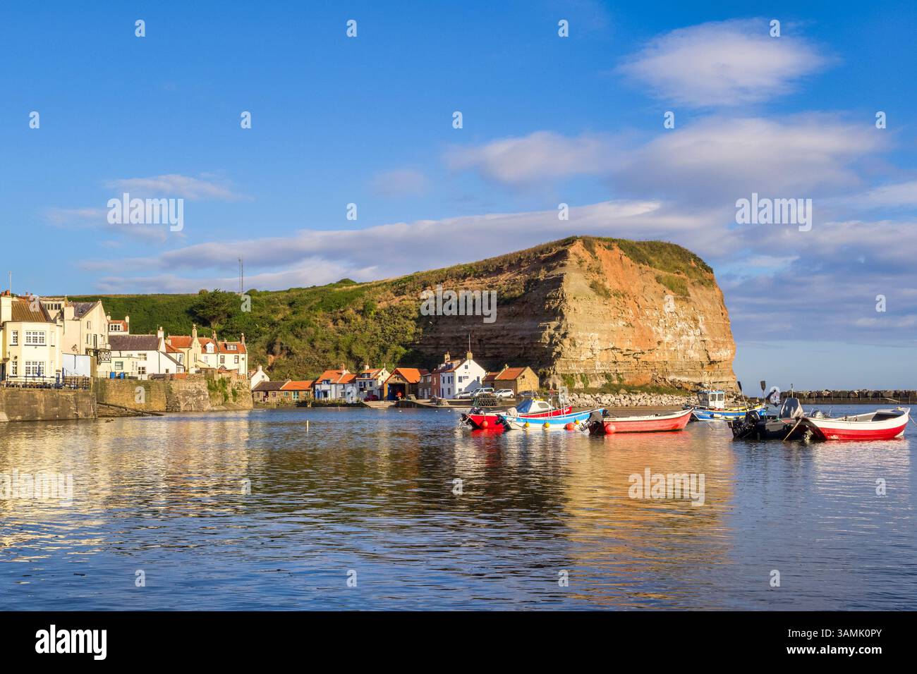 26 juillet 2024 : Staithes. North Yorkshire, Royaume-Uni - le port, le village et la falaise de Staithes par un beau matin d'été à marée haute. Banque D'Images