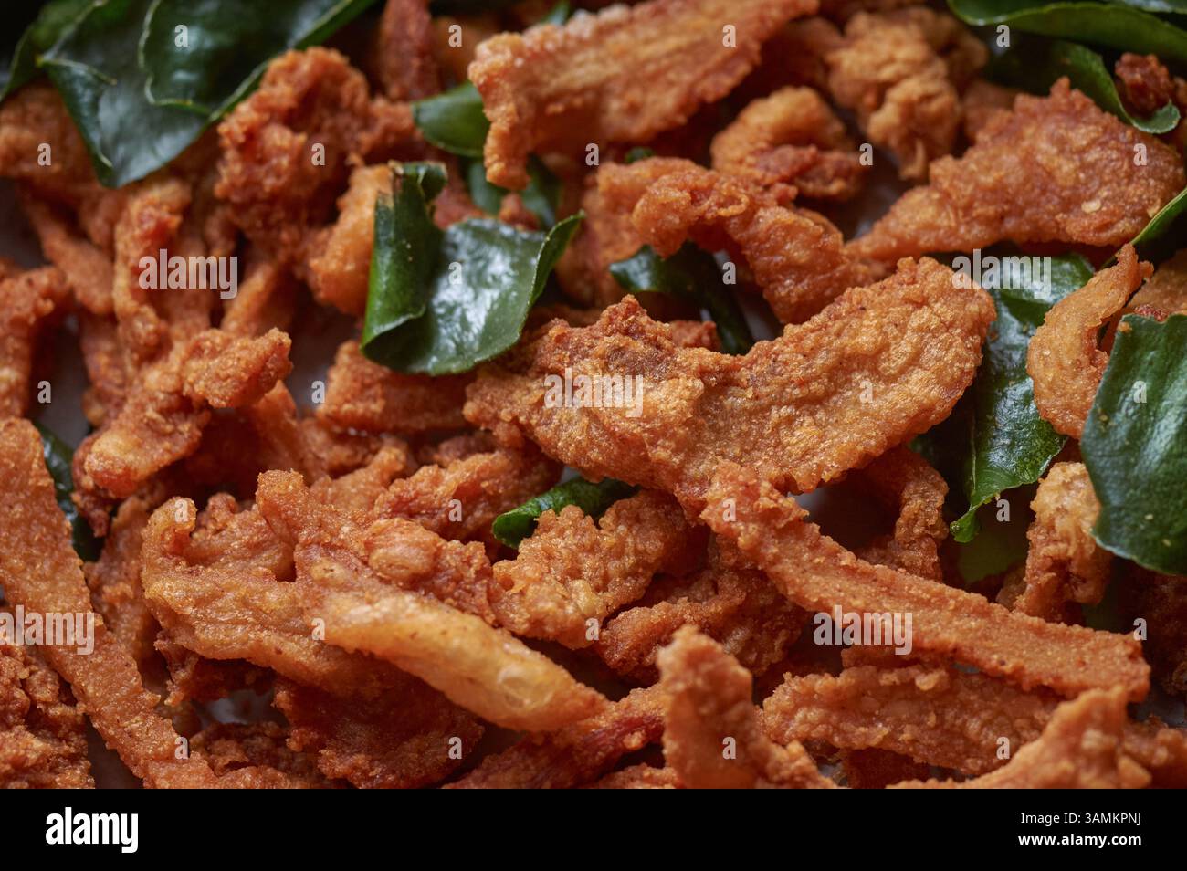Croûtes de porc croustillantes de style thaïlandais avec feuilles de citron vert Kaffir Banque D'Images