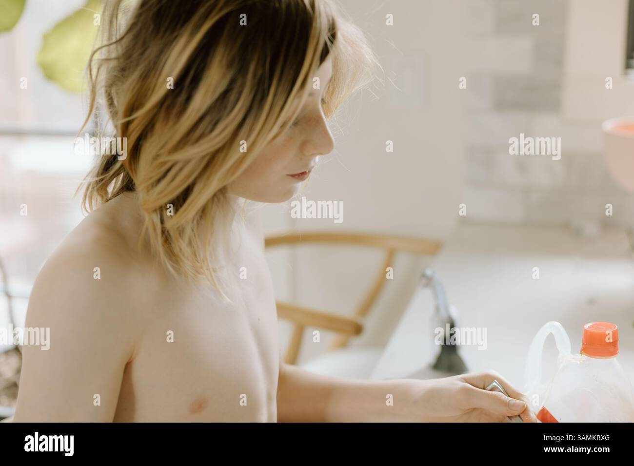 Adolescent concentré sur la préparation du petit déjeuner avec des toasts et des fraises Banque D'Images