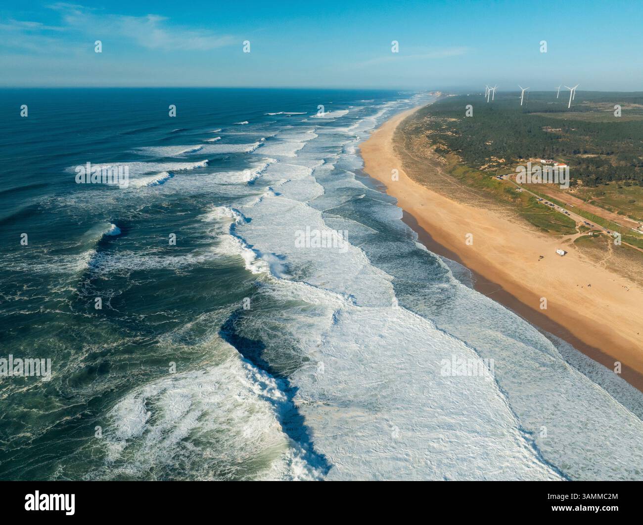 Vue aérienne de Praia do Norte avec de belles vagues et éoliennes, Leiria, Portugal. Banque D'Images