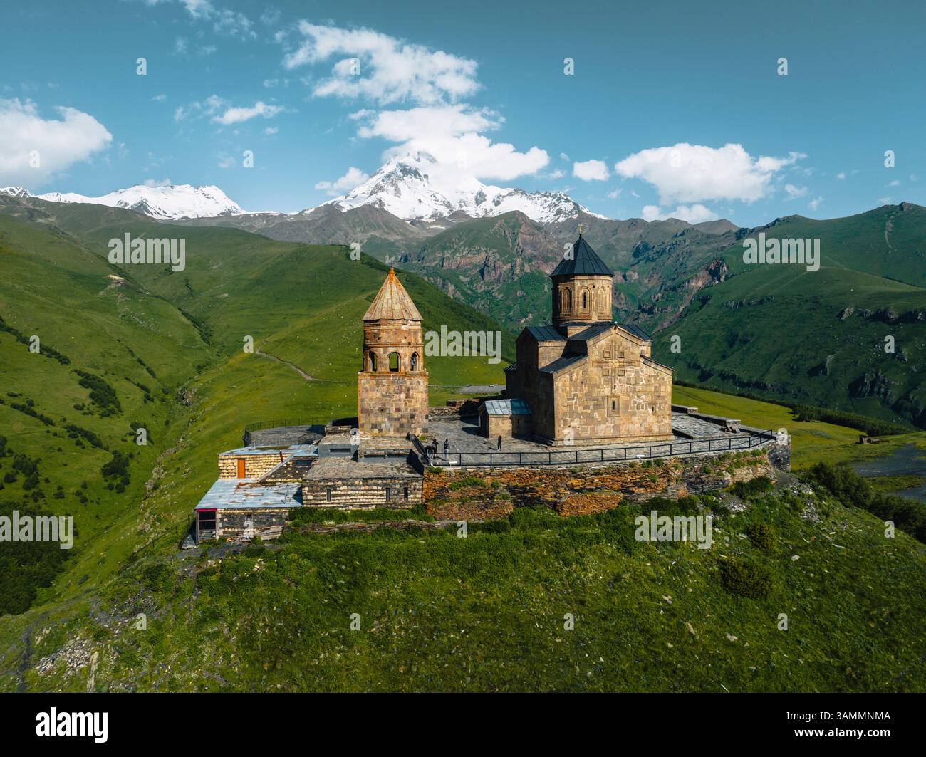 Vue aérienne de l'église gergeti trinity entourée de montagnes majestueuses et d'un paysage tranquille, Stepantsminda, Géorgie. Banque D'Images