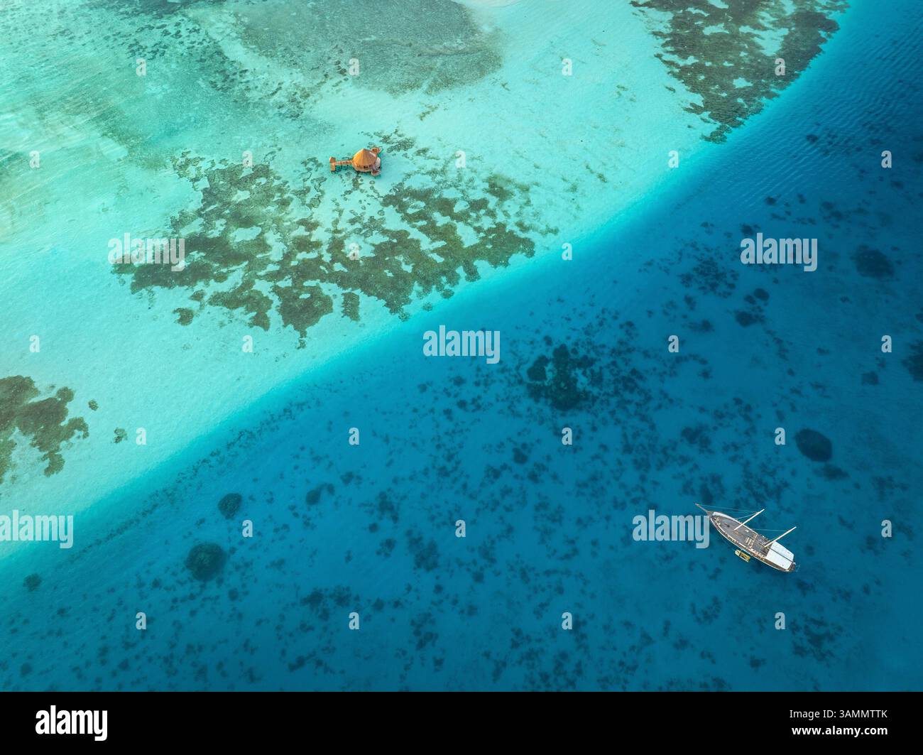 Vue aérienne de la belle eau turquoise et récif corallien avec un bateau dans un paradis tropical, Amingiri, Malé Atoll, Maldives. Banque D'Images