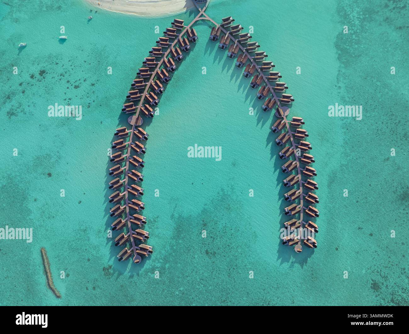 Vue aérienne de l'île de Kuredhivaru avec des bungalows luxueux sur l'eau turquoise, atoll de Noonu, Maldives. Banque D'Images