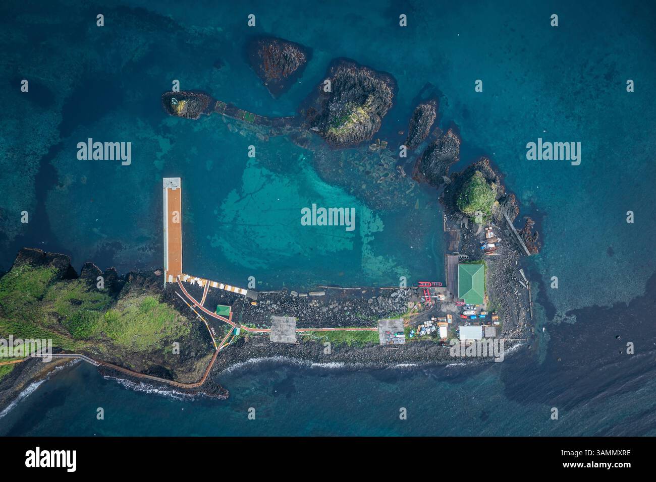 Vue aérienne de l'île de Moneron avec côte rocheuse et eau bleue, oblast de Sakhaline, Russie. Banque D'Images
