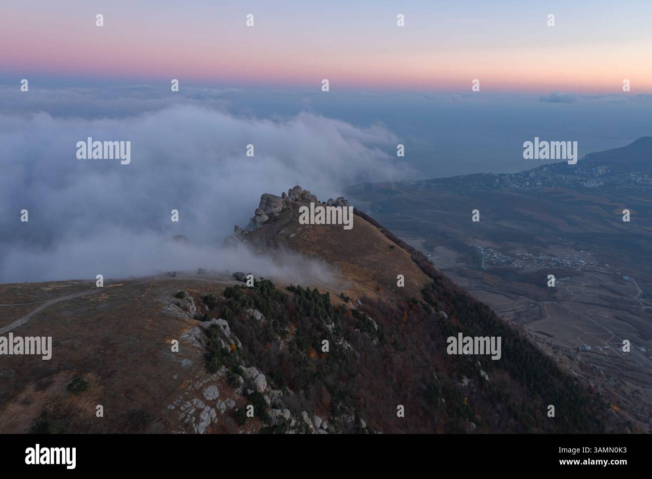 Vue aérienne d'un paysage de montagne avec des arbres forestiers et des nuages bas au coucher du soleil dans la région de Crimée, République autonome de Crimée, Ukraine. Banque D'Images