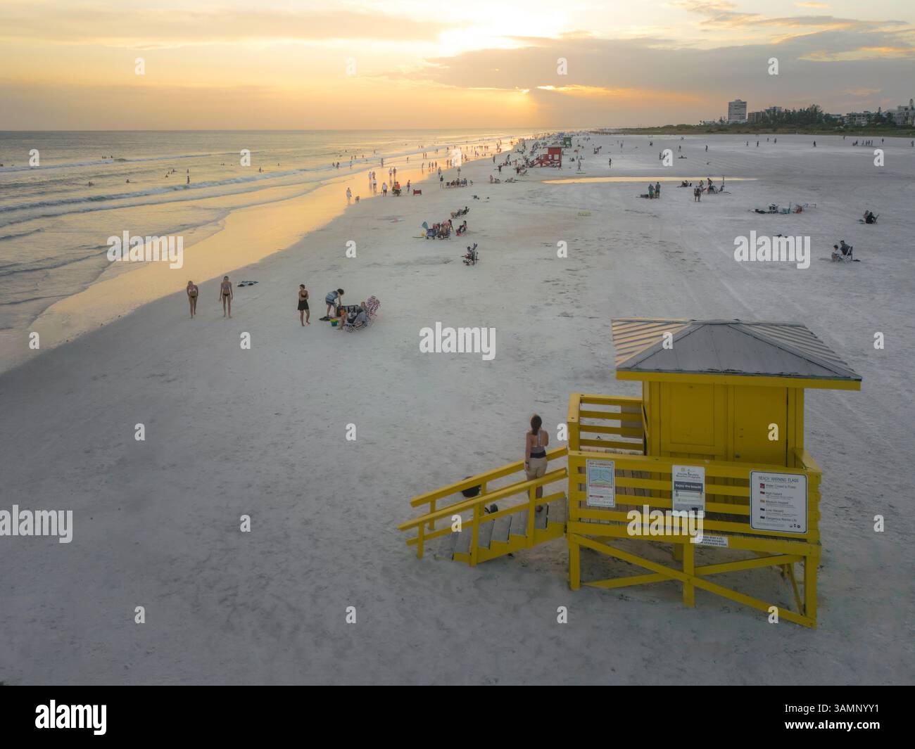Vue aérienne du coucher de soleil sur le golfe du Mexique avec une maison colorée de sauveteur et des gens sur la plage, Siesta Key, États-Unis. Banque D'Images