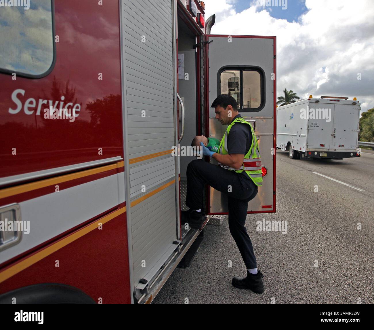 20 février 2014 - Miami, FL, États-Unis - Un ambulancier de Miami Fire-Rescue transporte Sebastian de la Cruz, 5 mois, qui avait cessé de respirer, à l'hôpital. La tante du bébé a pratiqué la RCR après avoir remorqué son VUS sur le côté de la route le long de la route d'État de Floride 836, juste à l'est de la 57e Avenue, le jeudi 20 février 2014. (Crédit image : © Al Diaz/MCT/ZUMAPRESS.com) Banque D'Images