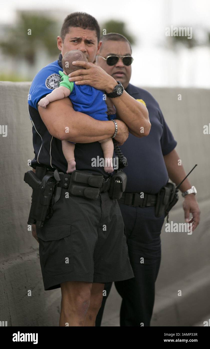 20 février 2014 - Miami, FL, États-Unis - Sweetwater, Fla., L'officier Amauris Bastidas garde un œil vigilant en attendant les ambulanciers paramédicaux après avoir aidé Sebastian de la Cruz, 5 mois, qui avait cessé de respirer. La tante du bébé a effectué une RCR après avoir tiré son VUS sur le côté de la route le long de la route 836 de l'État de Floride, juste à l'est de la 57e Avenue, le jeudi 20 février 2014, à Miami. (Crédit image : © Al Diaz/MCT/ZUMAPRESS.com) Banque D'Images