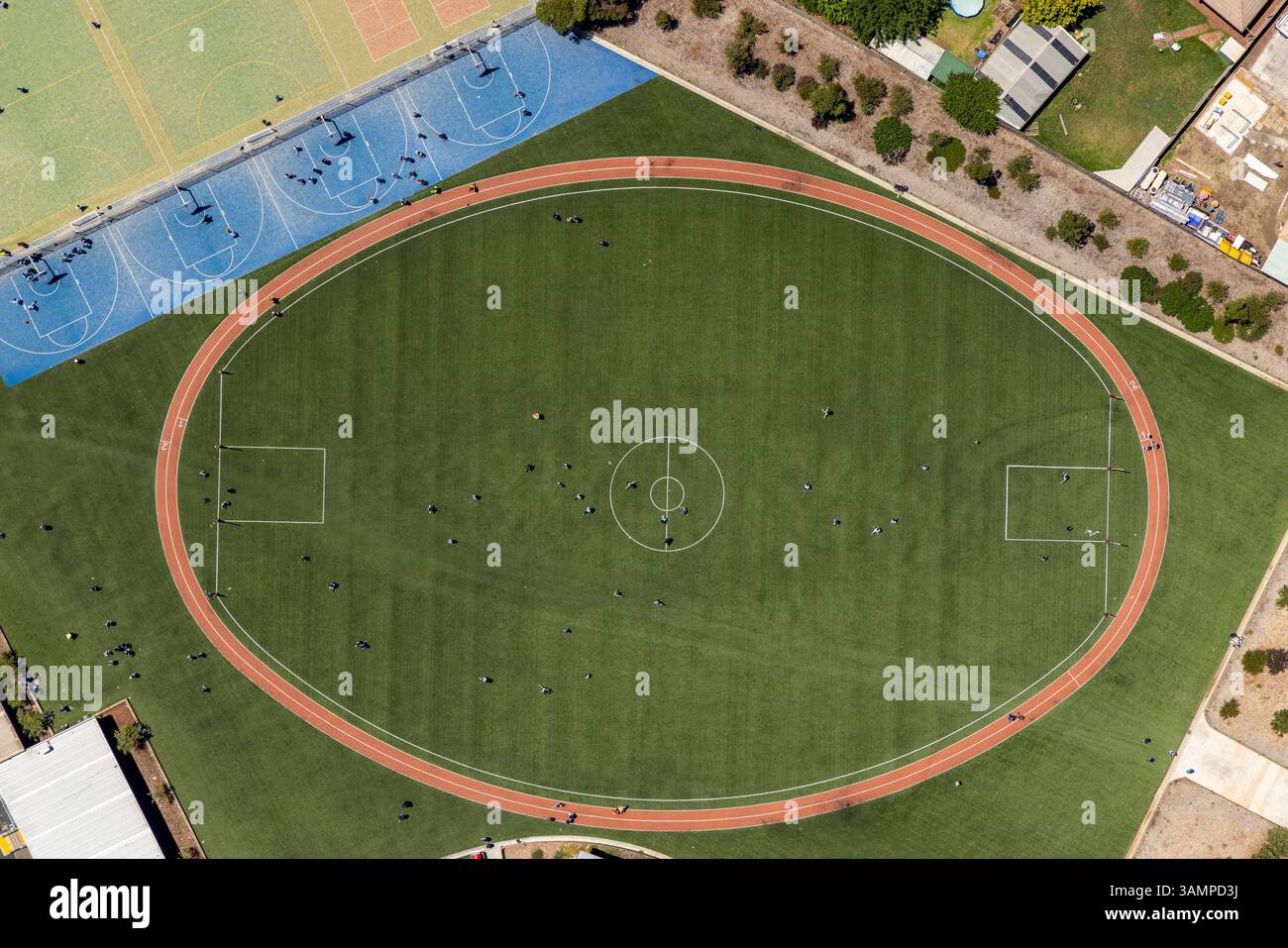Vue aérienne du terrain de sport et de la piste de course entourés de bâtiments et d'arbres, Melton West, Australie. Banque D'Images
