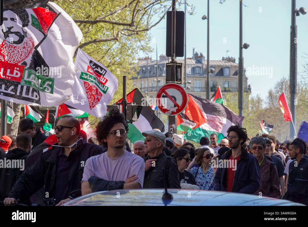 Les manifestants défilent avec des drapeaux et des banderoles lors d'un rassemblement / manifestation / manifestation pro-palestinien à Paris, avec un accent sur un drapeau avec un texte arabe Banque D'Images