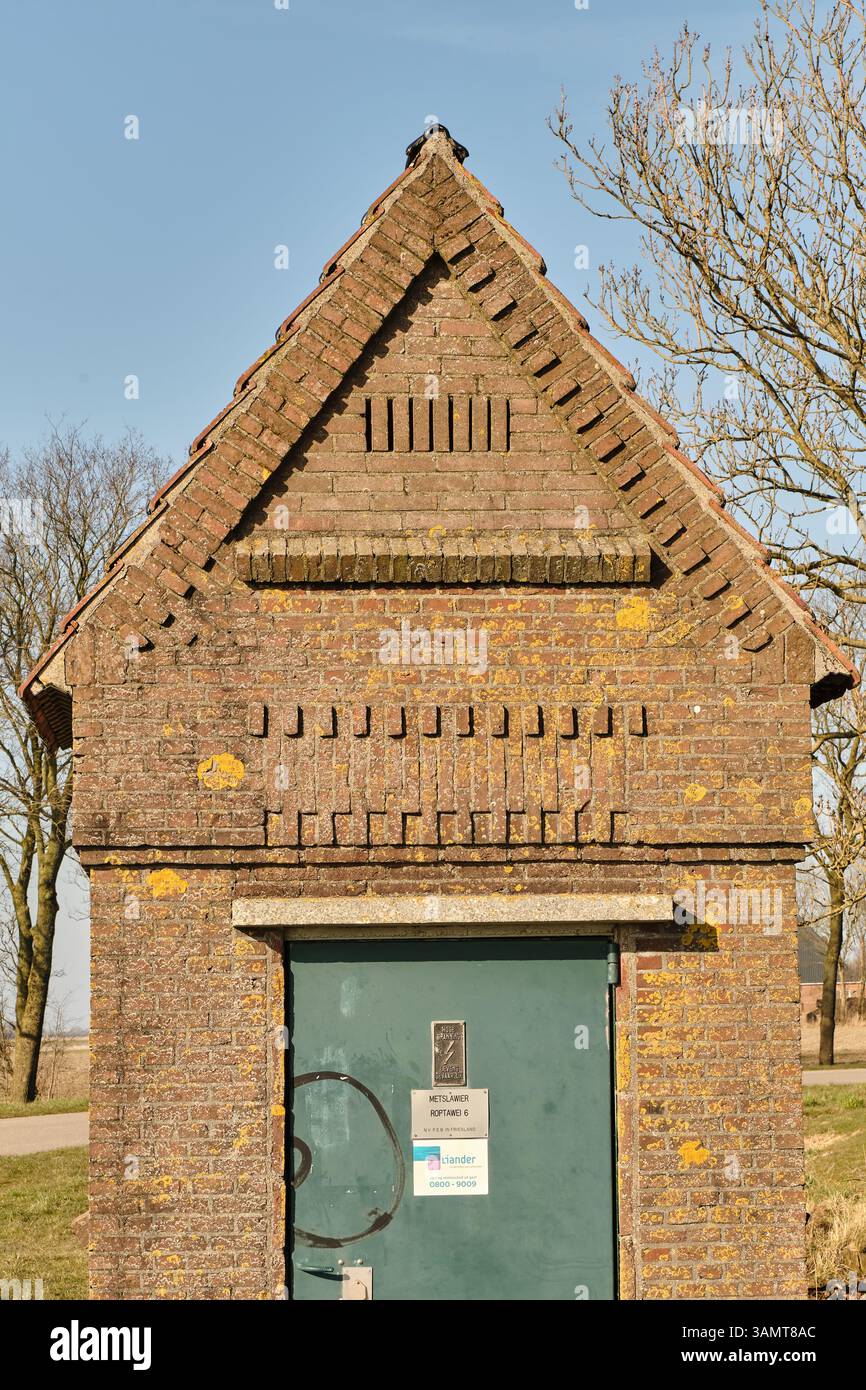8 mars 2025 - Ropta-pays-Bas : vue de face d'une ancienne maison de transformateur avec un design traditionnel en briques, située dans la zone rurale de Ropta, Friesla Banque D'Images