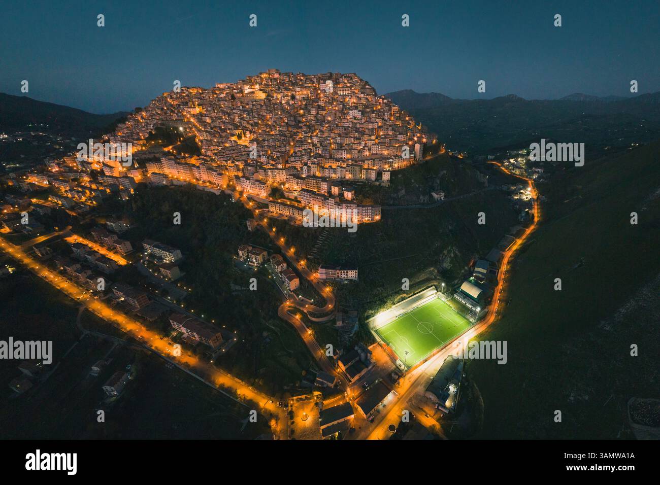 Vue aérienne panoramique des maisons et un terrain de football la nuit, Gangi, Sicile, Italie. Banque D'Images