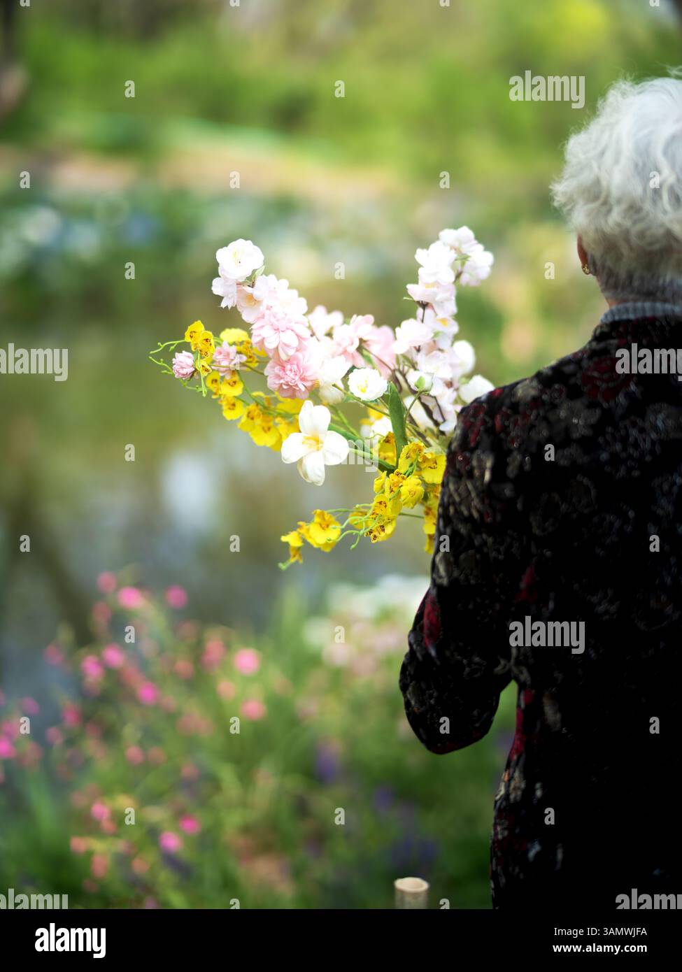 Élégante vieille femme aux cheveux argentés avec bouquet printanier vibrant - Un portrait poétique de la nostalgie et de la grâce naturelle Banque D'Images