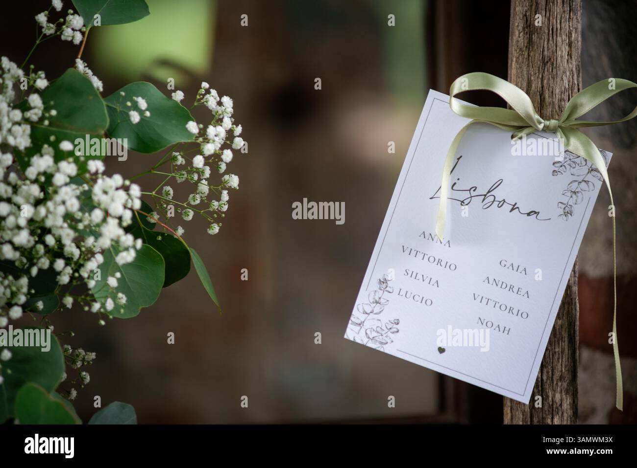 Une carte de place magnifiquement arrangée pour les invités à un lieu de mariage à Lisbonne. Les fleurs et la verdure rehaussent la configuration élégante. Banque D'Images