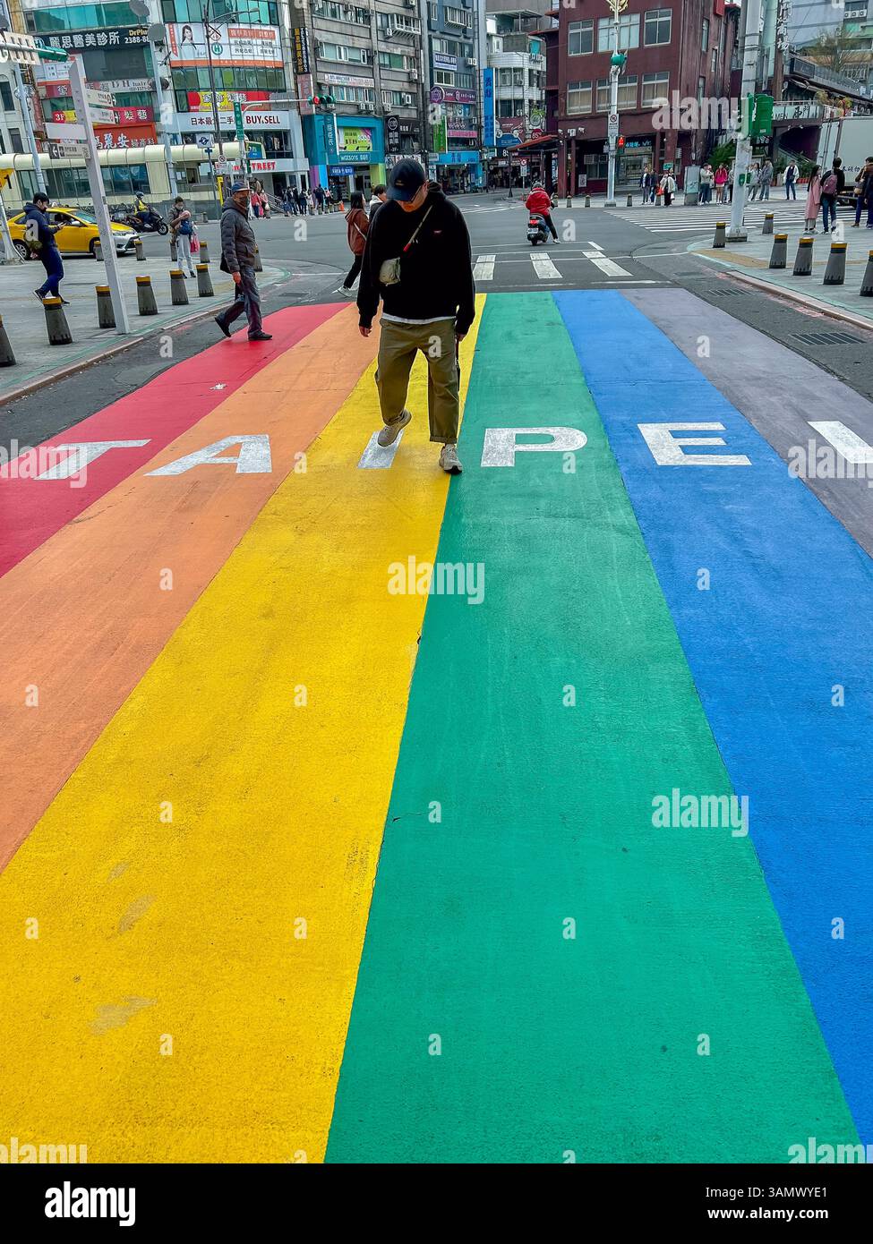 Taipei, Taiwan, Gay Asian Man, Grand Gay, LGBTQI + Gay Flag Painting on Street Crossing, scène, extérieur, jour, (Wanhua District, Ximen) Banque D'Images