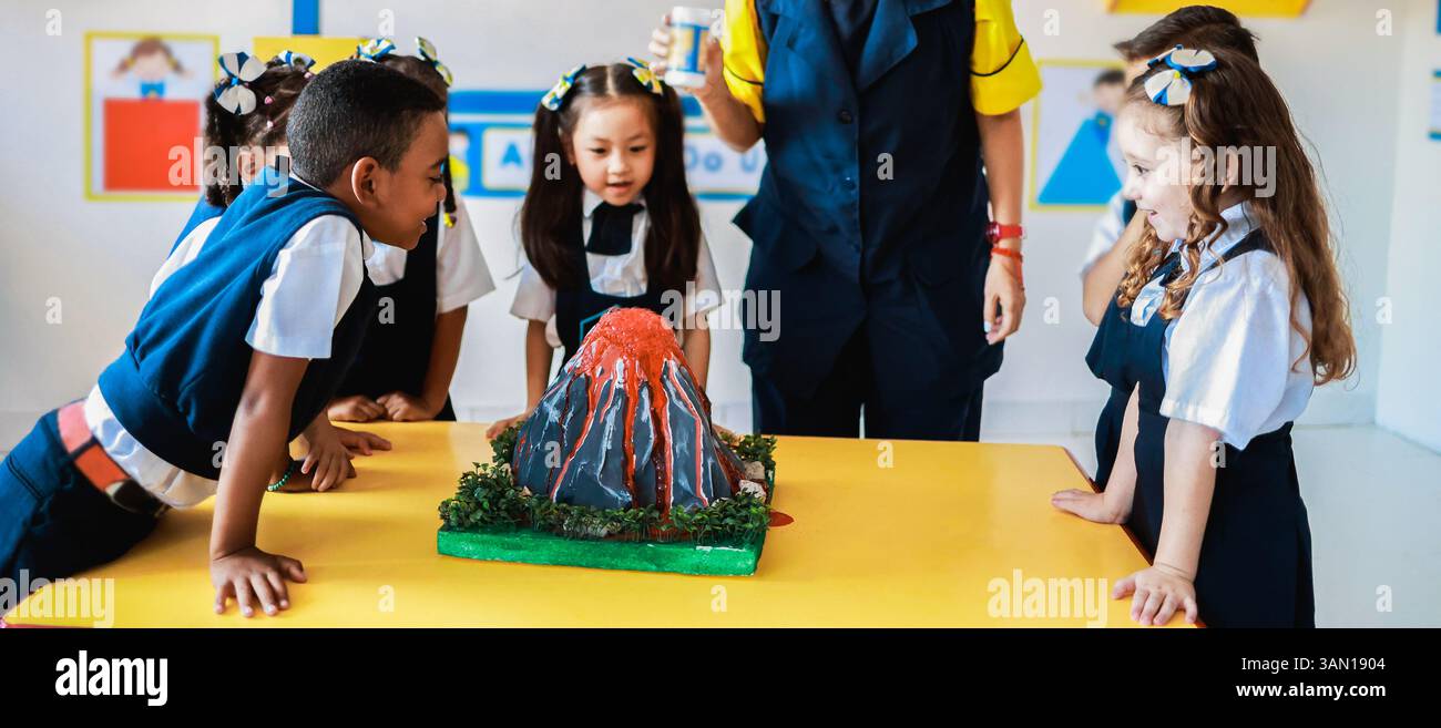 École, groupe d'enfants en classe de sciences apprendre sur les volcans à la salle de classe de la maternelle. Concept d'éducation Banque D'Images