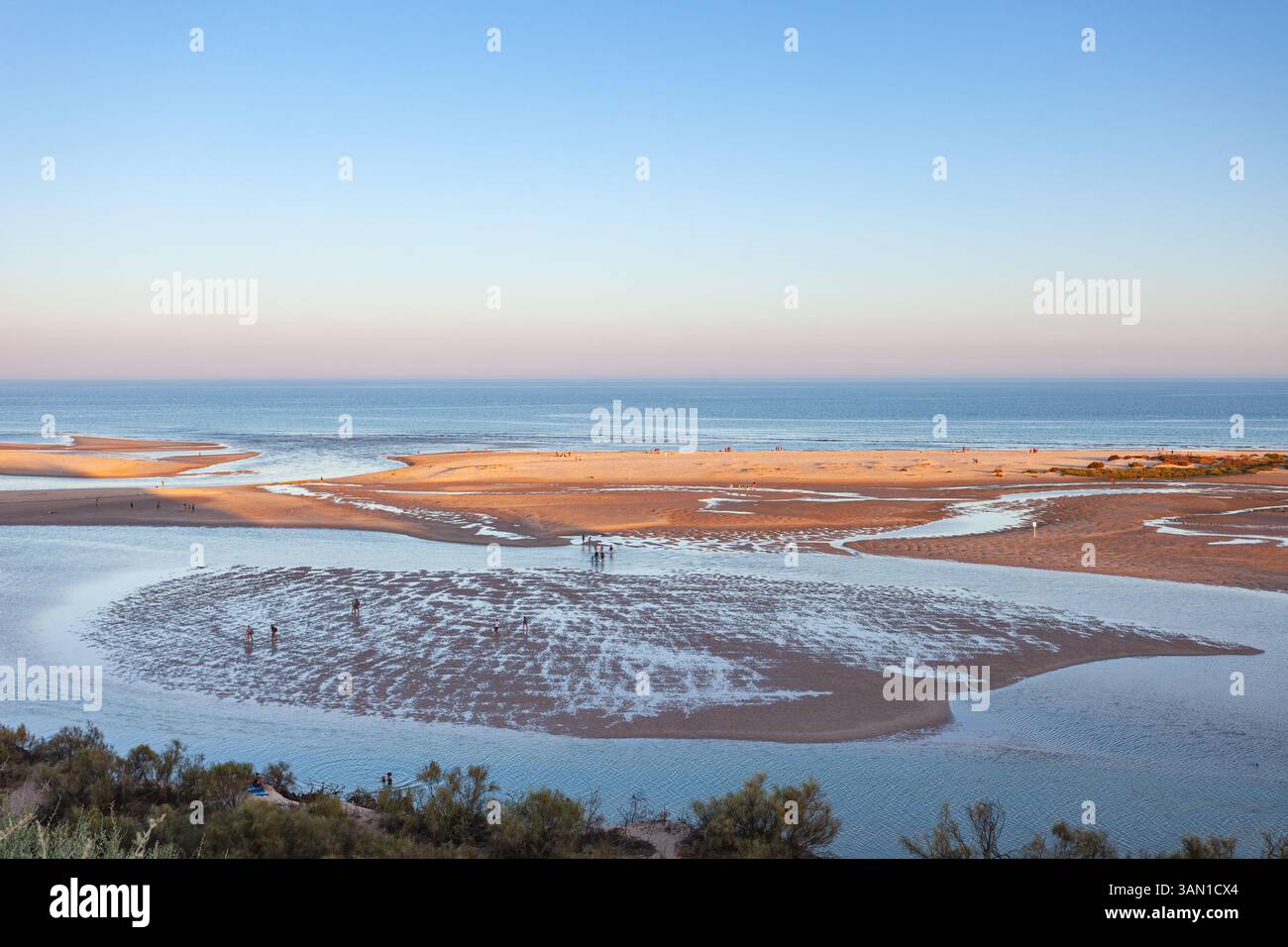 Les amateurs de plage traversant le lagon de la Ria Formosa à marée basse, vus du village de Cacela Velha situé au sommet d'une colline, Algarve, Portugal. Banque D'Images