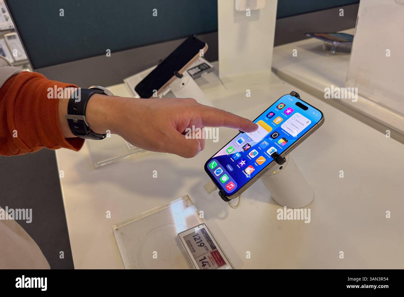 Main d'un homme essayant un iPhone en magasin Banque D'Images