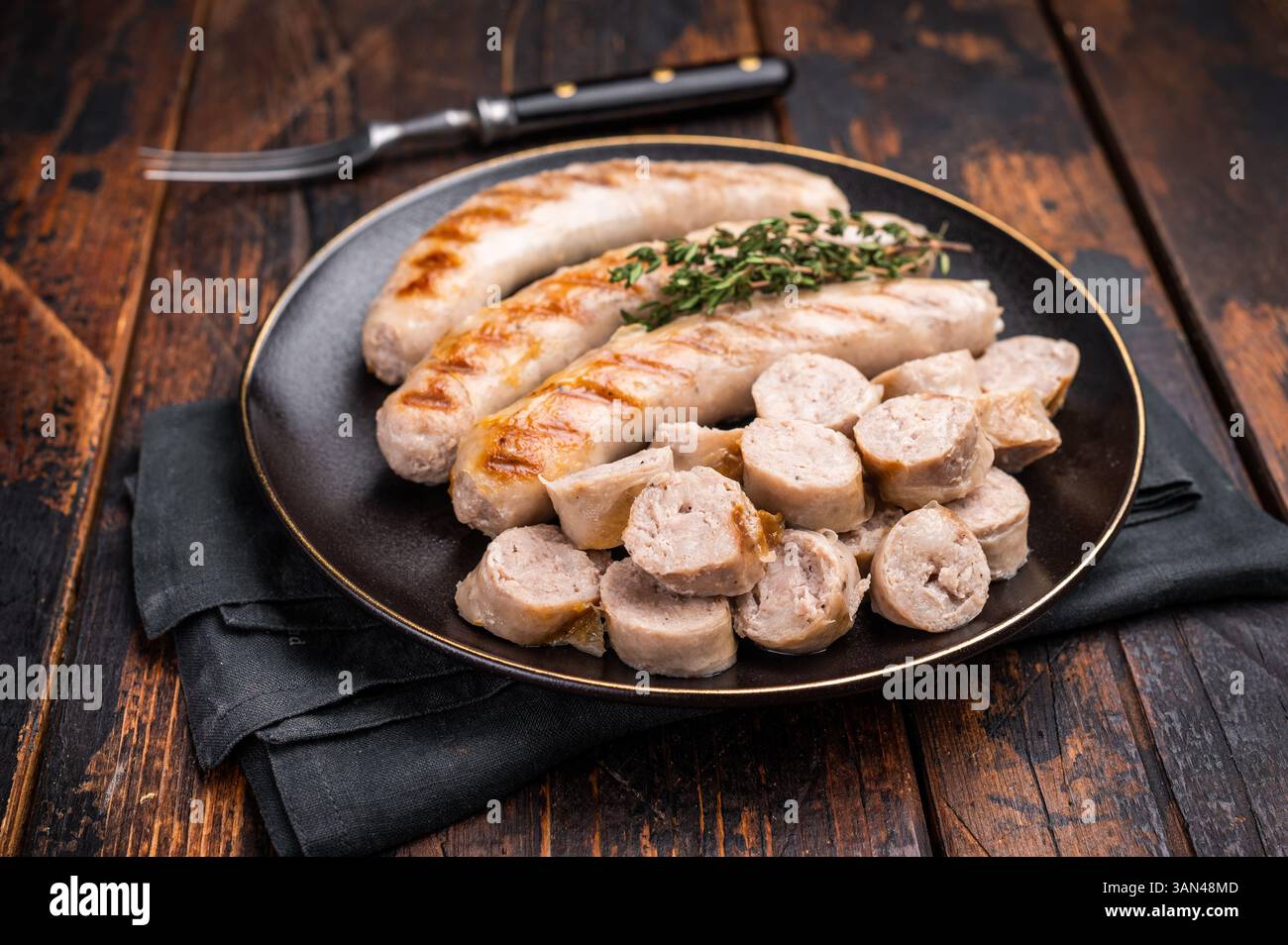 Saucisses grillées avec de la viande de forçage mincemat et des herbes dans l'assiette. fond en bois. vue de dessus. Banque D'Images