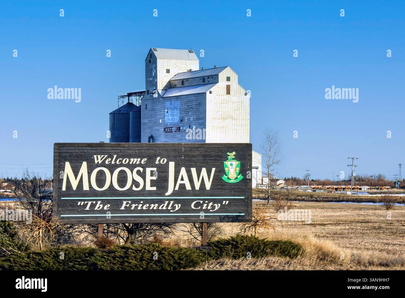Moose Jaw, Canada - 5 avril 2025 : Bienvenue à Moose Jaw signe avec élévateur à grain. Les silos à grain sont un spectacle courant en Saskatchewan, l’un des Canadiens Banque D'Images
