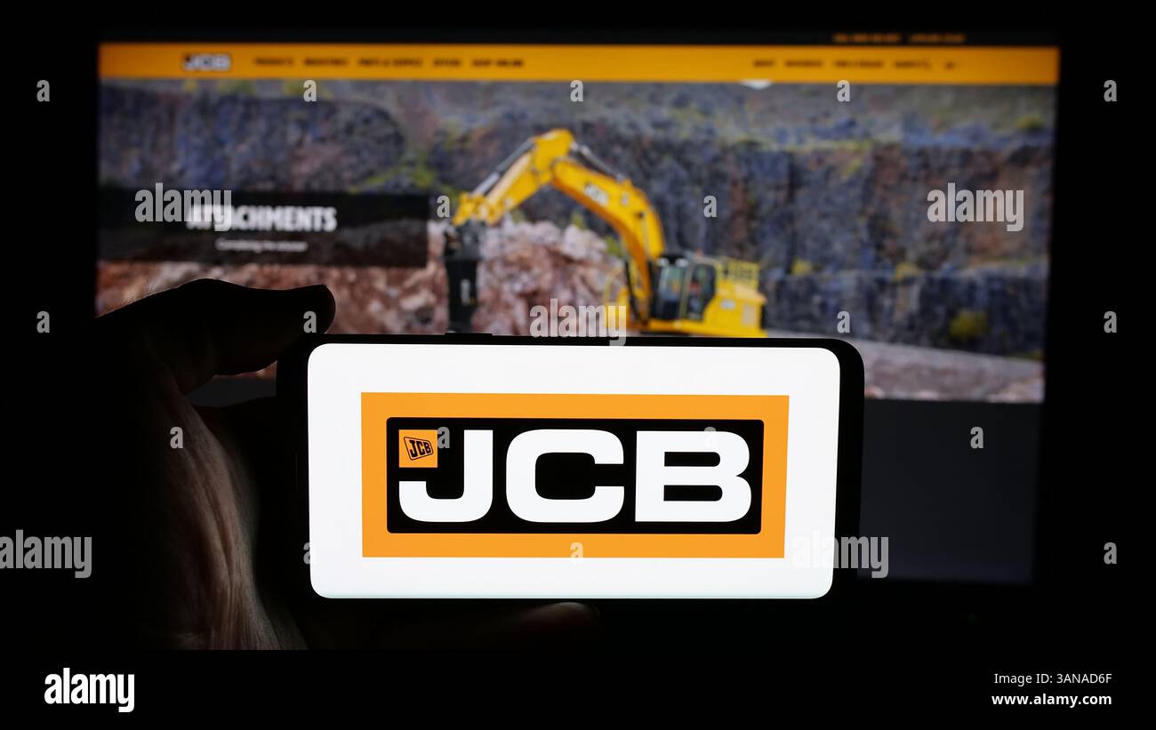 Allemagne. 4 mars 2025. Dans cette illustration photo, une personne tient un téléphone portable avec le logo de la société britannique J.C. Bamford Excavators Limited (JCB) sur l'écran devant la page Web de l'entreprise. (Crédit image : © timon Schneider/SOPA images via ZUMA Press Wire) USAGE ÉDITORIAL SEULEMENT ! Non destiné à UN USAGE commercial ! Banque D'Images