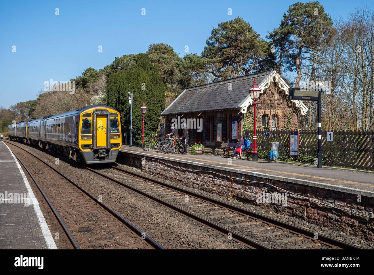 Les vététistes attendent sur le quai 1 à la gare d'Armathwaite pour monter à bord du train 15,04 à destination de Leeds, Armathwaite, Westmorland & Furness, Cumbria, Royaume-Uni Banque D'Images