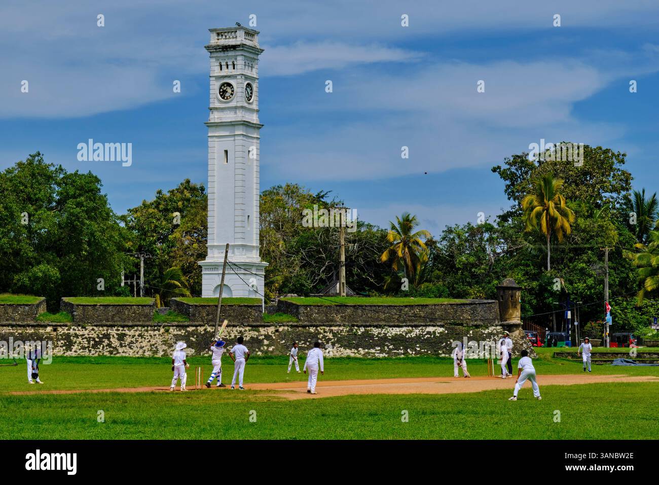 Sri Lanka, Province du Sud, district de Matara, Matara, enfants jouant au cricket devant la tour de l'horloge du Fort de Matara Banque D'Images