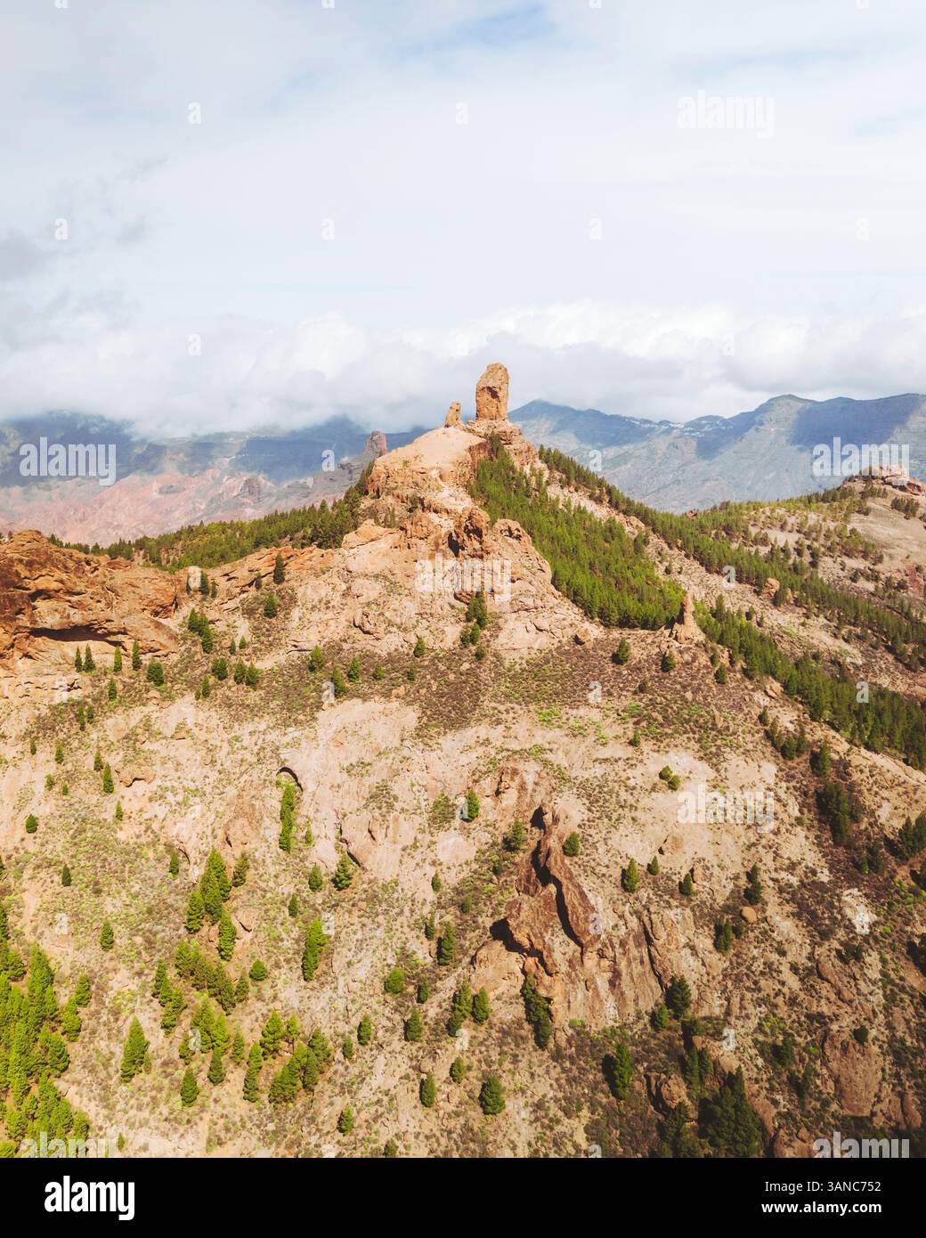 Vue aérienne de la majestueuse formation rocheuse de Roque Nublo entourée d'une forêt sereine et de nuages, Tejeda, Espagne. Banque D'Images