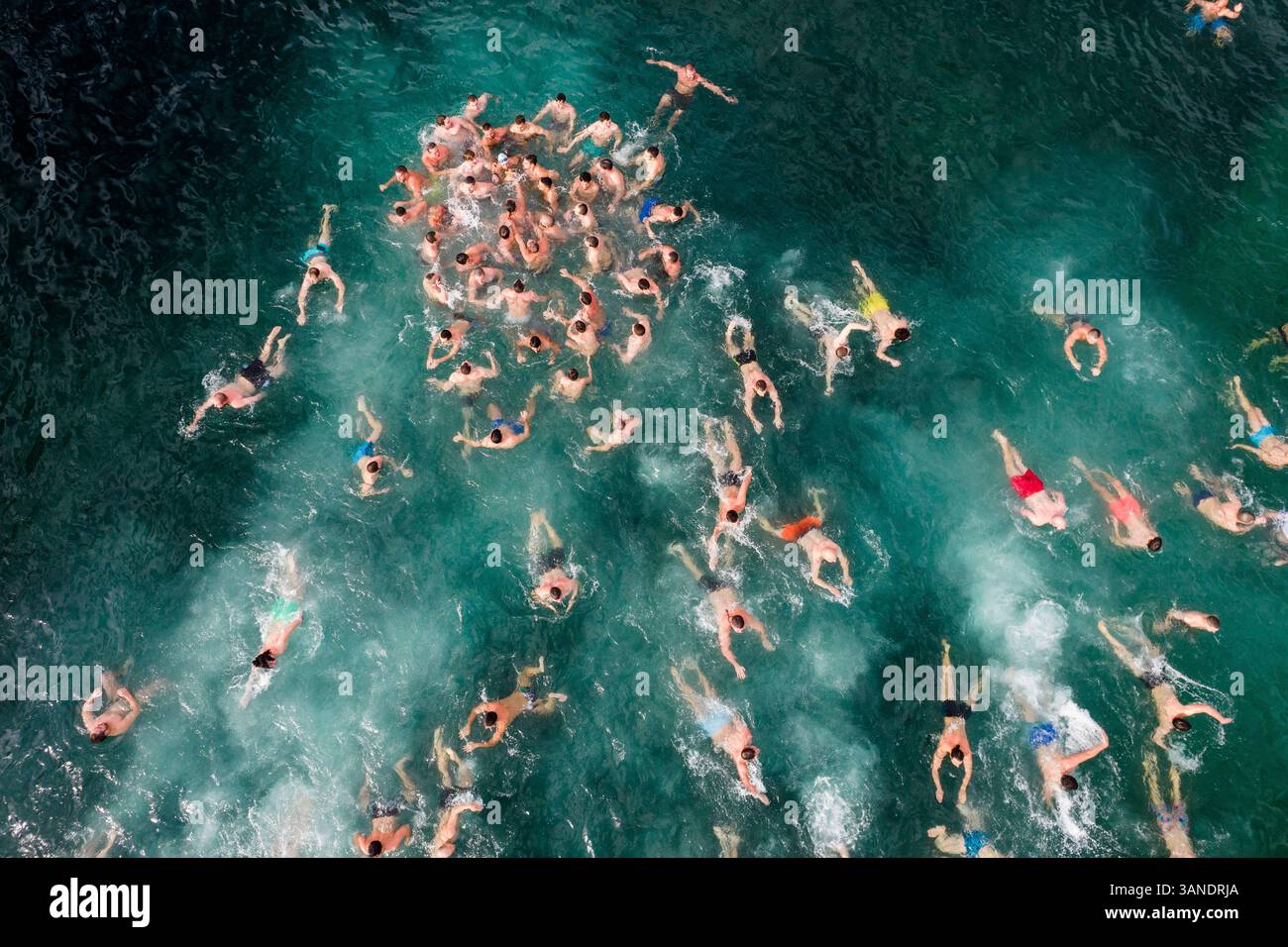 Drone aérien vue de personnes nageant dans l'eau froide en hiver, Epiphany Christian Holiday, Varna, Bulgarie. Banque D'Images