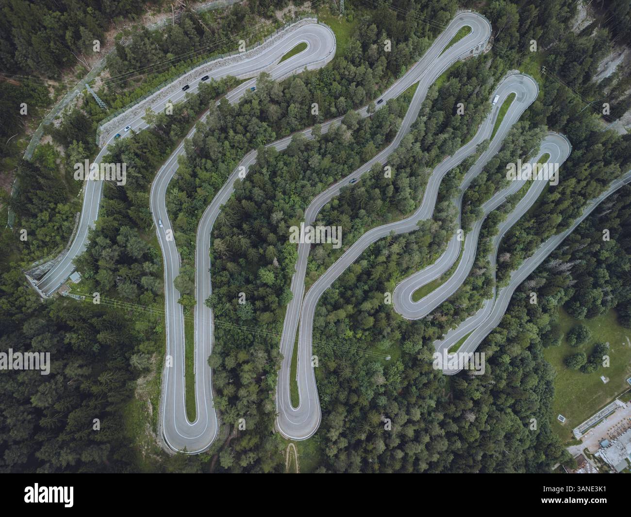Vue aérienne du col de montagne SS26 sinueux à travers une forêt verdoyante et des montagnes majestueuses, pré-Saint-Didier, Italie. Banque D'Images
