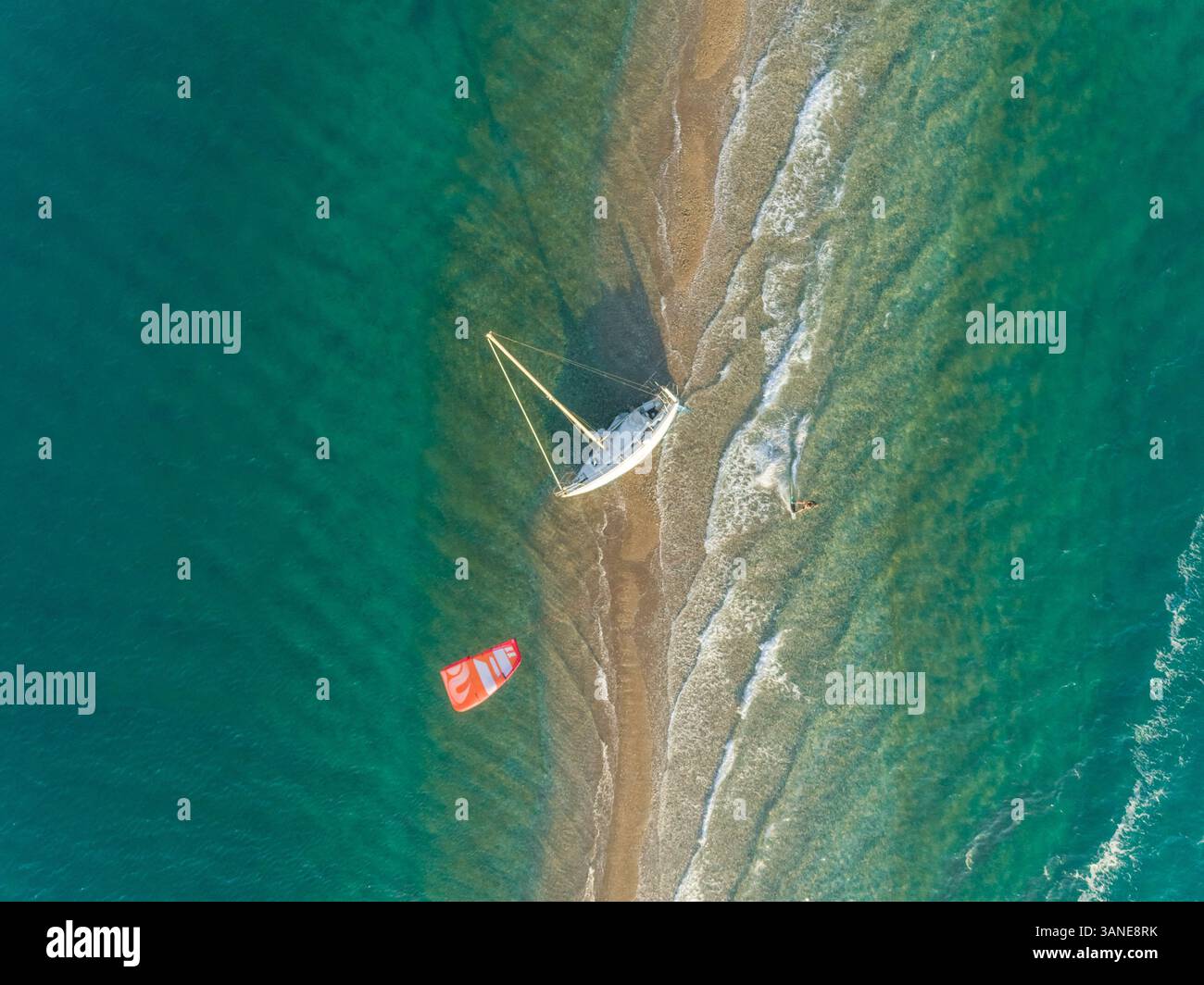 Vue aérienne de la personne kitesurf autour d'un voilier échoué dans le golfe de Patras, Grèce. Banque D'Images