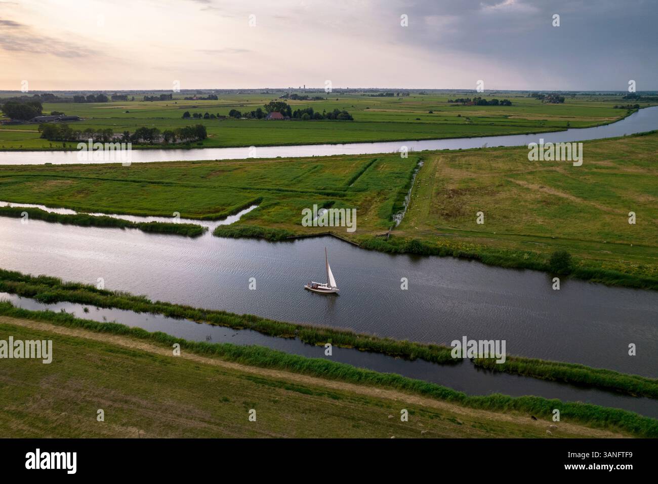 Vue aérienne du lac tranquille avec des voiliers au coucher du soleil, Earnewald, pays-Bas. Banque D'Images
