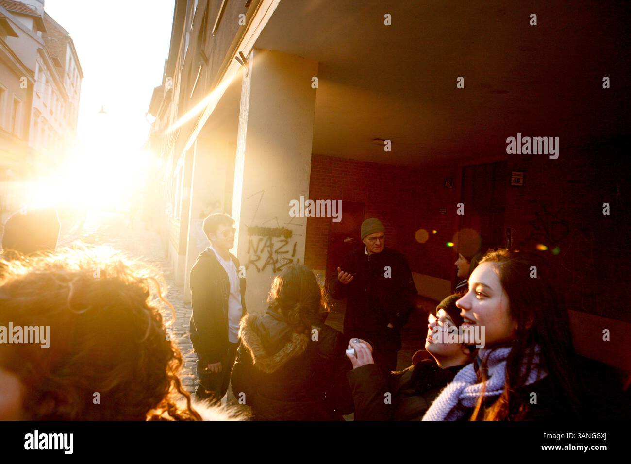 27 février 2010 - Cracovie, Pologne - des étudiants américains s'arrêtent devant grafitti près de la vieille synagogue de Kazimerz. Avant la chute du communisme en Pologne, l’ancien quartier juif de Kazimerz à Cracovie était délabré et dangereux à visiter la nuit. Aujourd'hui, la région attire des milliers de touristes par an du monde entier. Le quartier était autrefois un centre animé de la vie juive avant d'être anéanti pendant la seconde Guerre mondiale. Les restaurants et cafés à thème juif servent une cuisine traditionnelle juive et polonaise et les synagogues restaurées contiennent des expositions détaillant la vie juive d'avant-guerre en Pologne. Une certaine controverse Banque D'Images