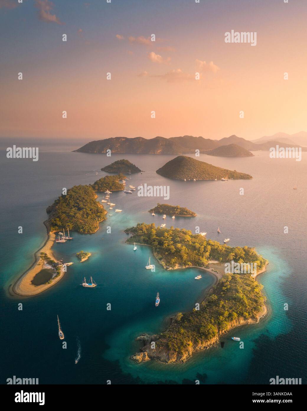 Vue aérienne d'une île sereine et pittoresque avec des eaux turquoises et des voiliers, province de Mugla, Turquie. Banque D'Images