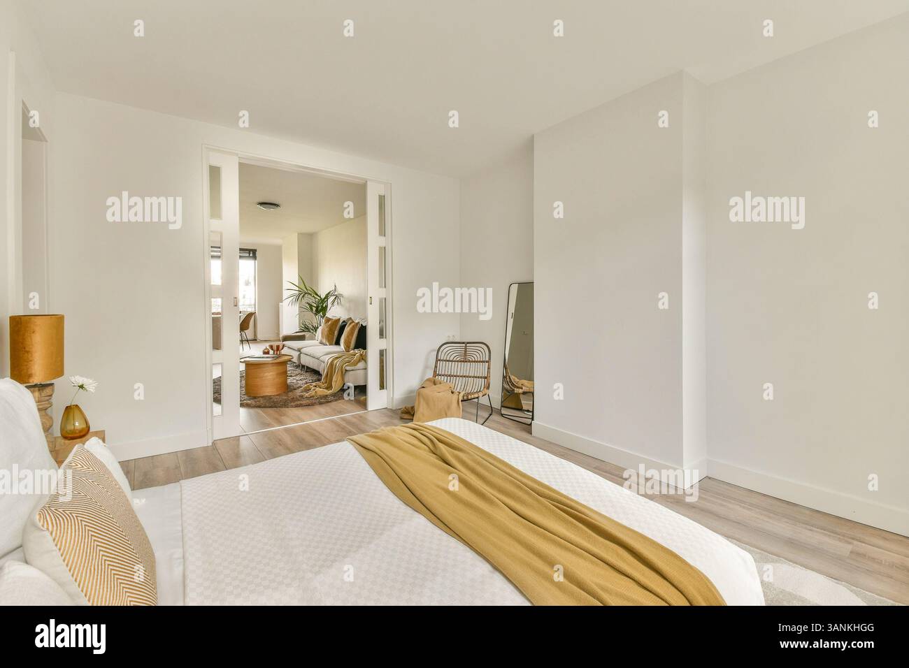Une chambre moderne spacieuse et lumineuse avec un lit confortable avec des draps moelleux. Les lignes épurées et les tons neutres créent une atmosphère sereine. Banque D'Images