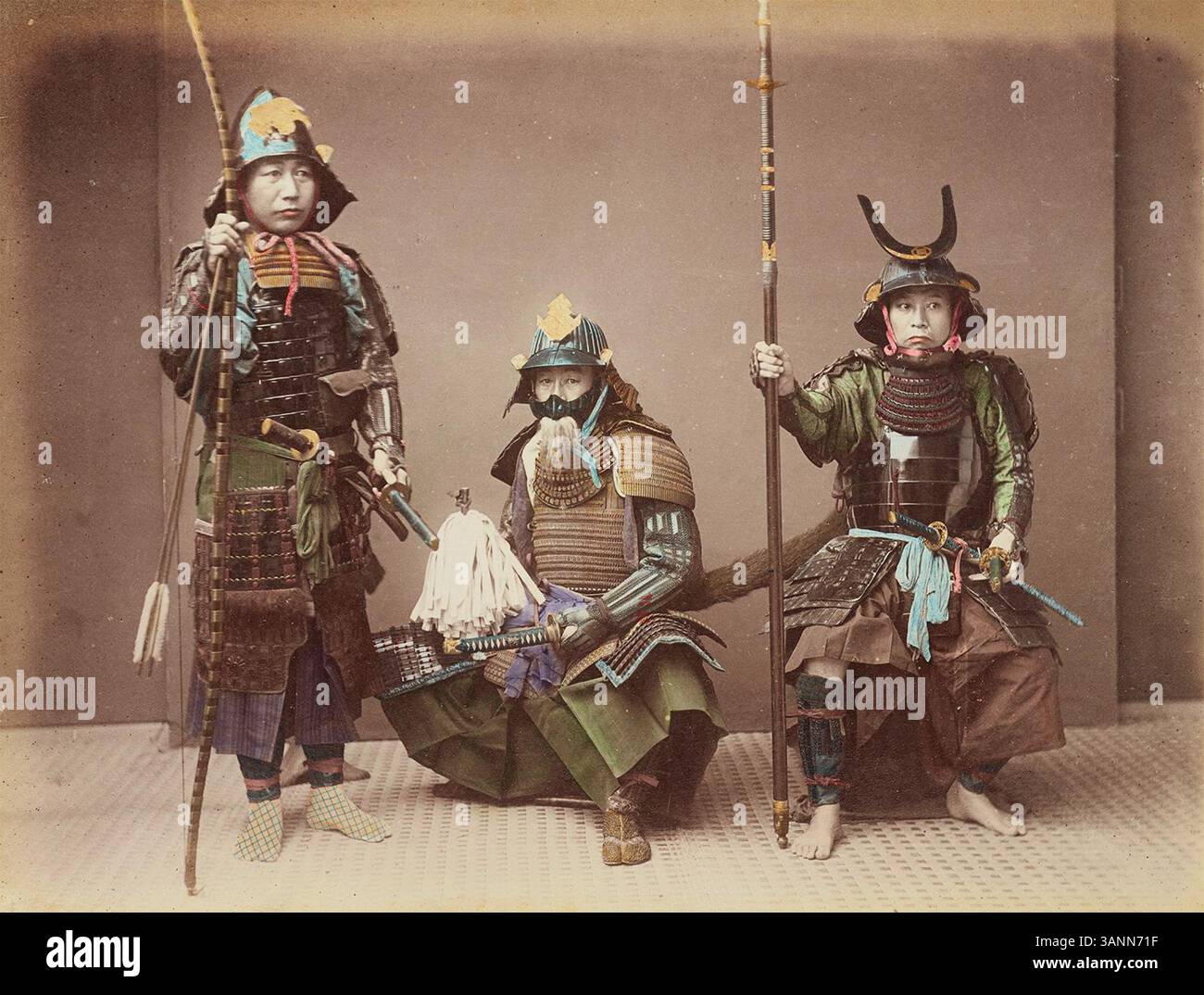 Cet imprimé argenté à l'albumen coloré à la main par Kusakabe Kimbei des années 1860 présente des samouraïs en armure traditionnelle. La photographie montre la classe guerrière de l'Empire du Japon, mettant en évidence leurs armes telles que le yumi (arc), le katana (épée) et le yari (lance). Banque D'Images