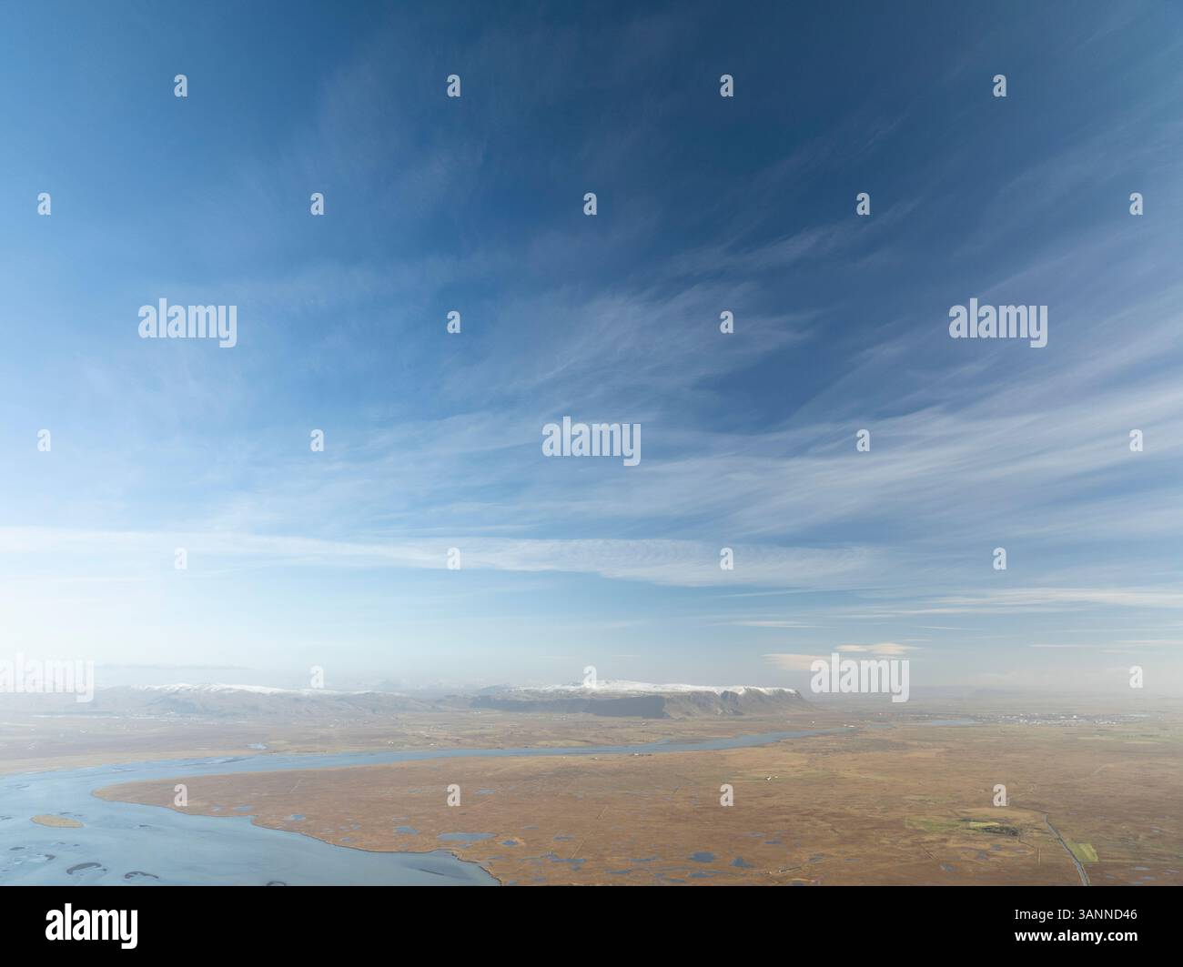 Vue aérienne du paysage serein et expansif sous un ciel bleu clair avec de beaux nuages, Olfus, Islande. Banque D'Images