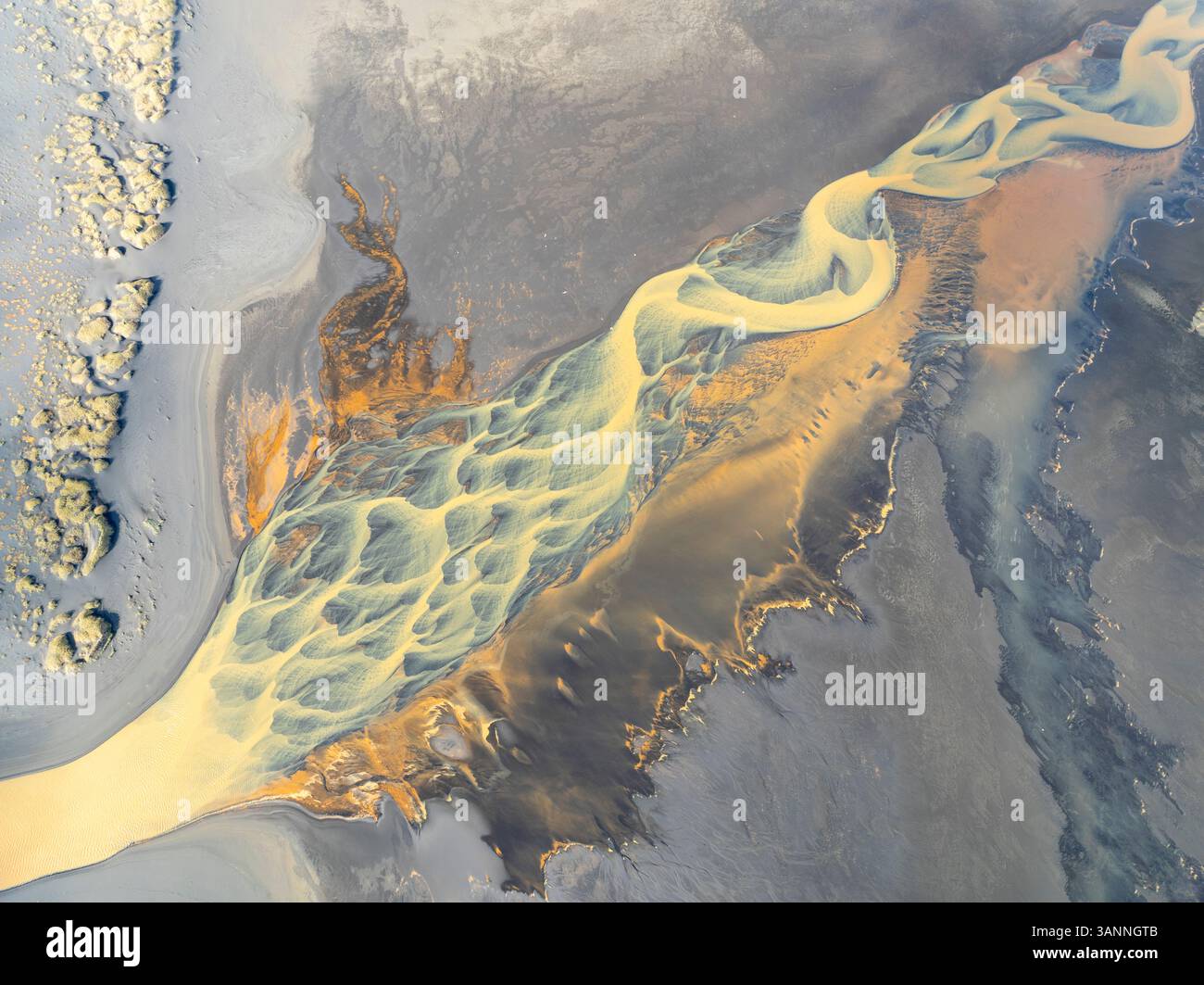 Vue aérienne d'une belle et vibrante rivière avec des motifs abstraits coulant à travers un paysage serein, Hvolsvollur, Islande. Banque D'Images
