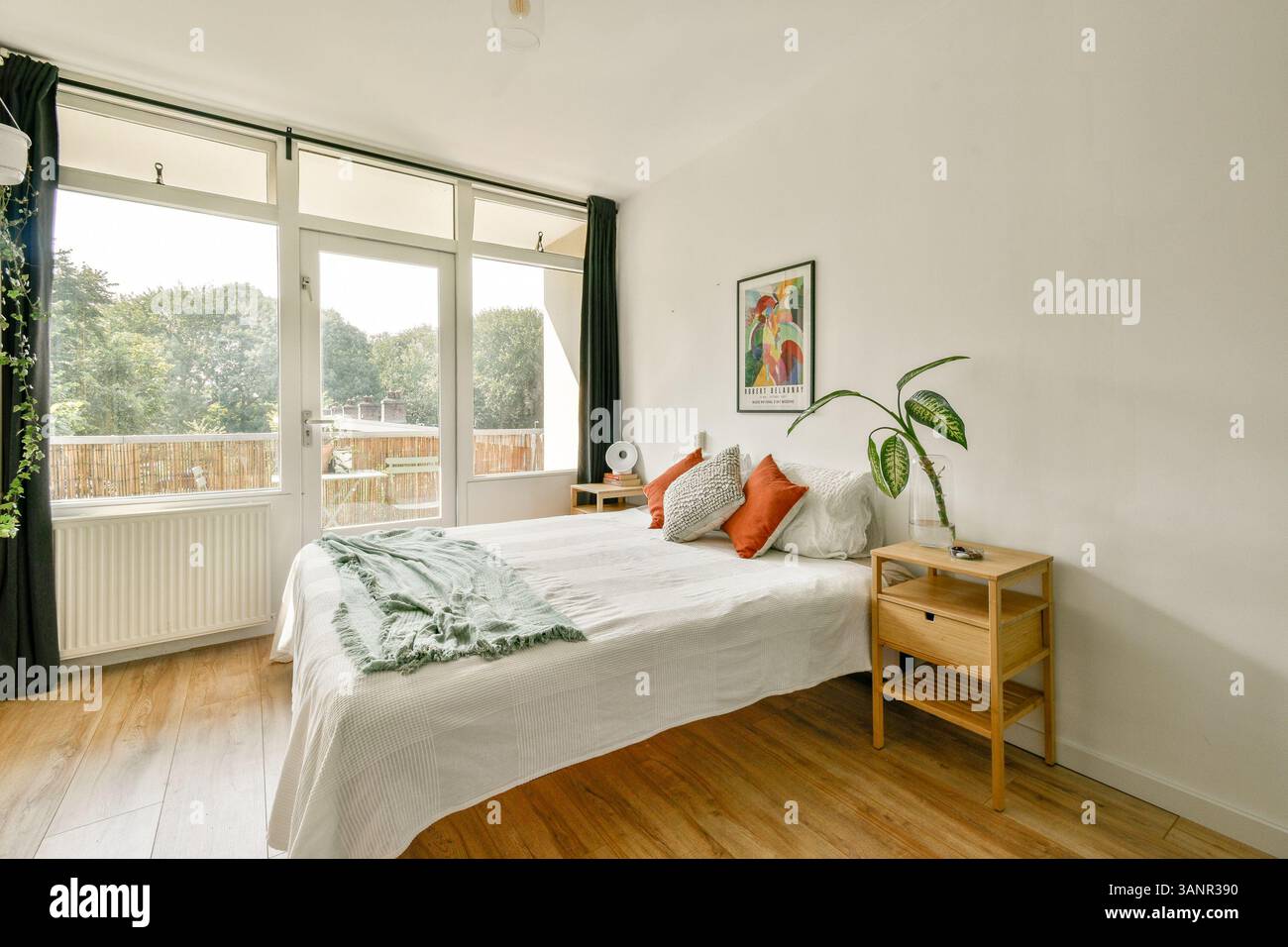 Une chambre moderne lumineuse et accueillante avec un lit confortable, un éclairage naturel et des éléments de décoration élégants, idéale pour la détente et le confort. Banque D'Images
