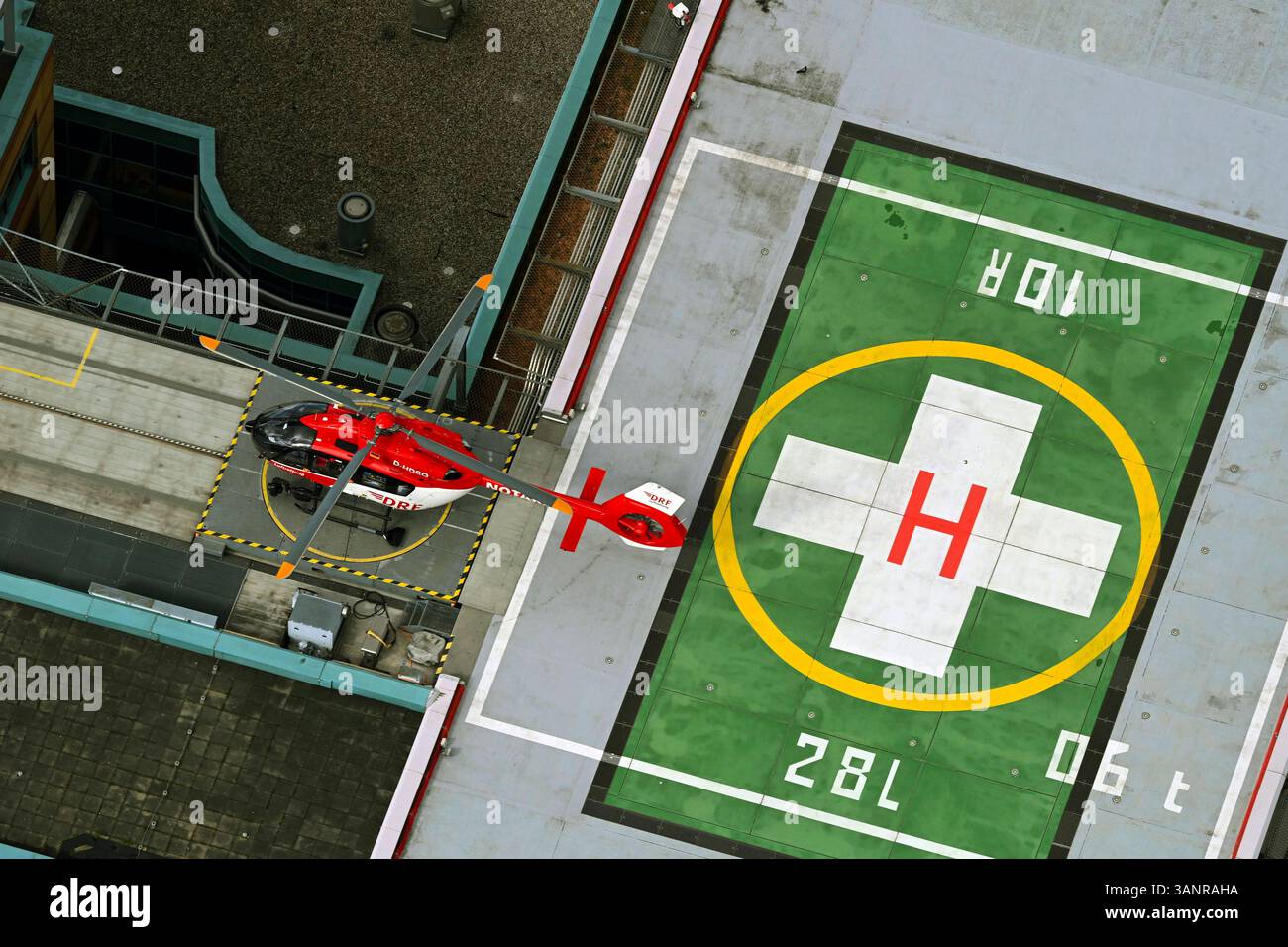 Berlin, Deutschland - 28 mars 2023 : vue aérienne d'un hélicoptère rouge atterrissant sur un héliport entouré de bâtiments urbains, Marzahn-Hellersdorf, Berlin, Banque D'Images