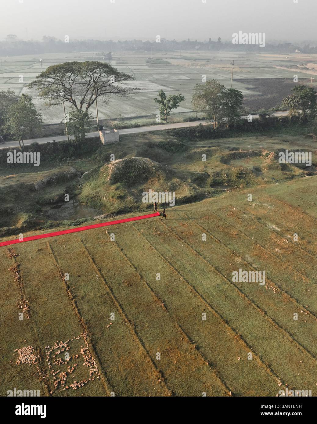Vue aérienne d'une usine de tissu avec des gens séchant des tissus au milieu d'un paysage rural, Paikar Char, Narsingdi, Dhaka, Bangladesh. Banque D'Images